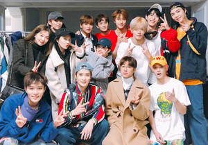 一群年輕人在服裝店裡擺出和平手勢。 — Nct 127 壁紙