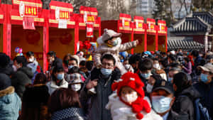 一群戴著口罩的人們在一個紅色裝飾的戶外節日活動中。 — 唐人街 壁紙