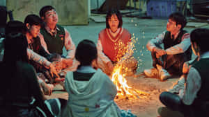 穿著校服的青少年在夜晚聚集在廢棄空地上的營火旁。 — 死亡 壁紙