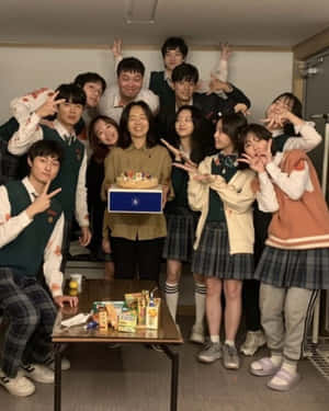 穿著校服的青少年在室內用蛋糕和笑容慶祝生日。 — 死亡 壁紙