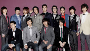 一群穿著西裝和領結的時尚年輕男子在攝影棚中擺姿勢。 — Super Junior 壁紙