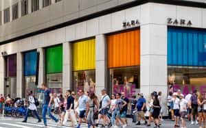 行人在Zara商店前過馬路，商店有彩色櫥窗。 — Zara 壁紙