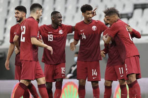 身穿紅色球衣的足球運動員在體育場場地上慶祝進球。 — FIFA 世界盃 壁紙