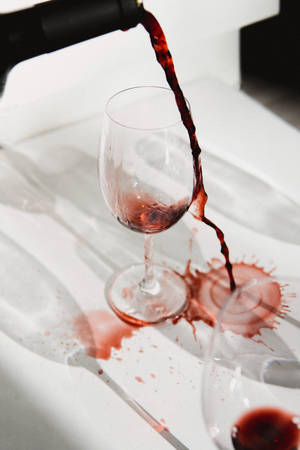 紅酒倒入玻璃杯中，在白色桌子上濺起水花。 — 葡萄酒 壁紙