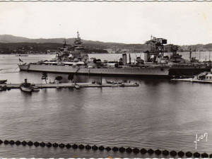 一艘大型戰艦停泊在港口，背景有山丘。 — 幽靈船 壁紙