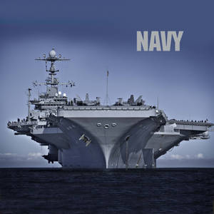 一艘大型灰色海軍航空母艦在海洋上航行，上方有「NAVY」文字。
