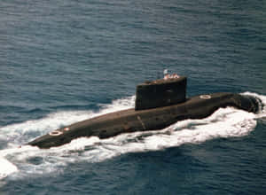 軍用潛艇在開闊海洋中浮出水面，指揮塔上可見船員。 — 水肺潛水 壁紙