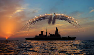 夕陽下的軍艦與直升機在海洋上空釋放照明彈 — 軍事動圖 壁紙