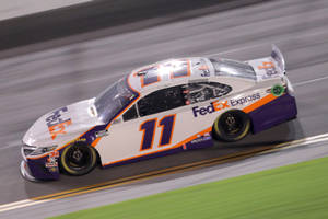 FedEx Express NASCAR 賽車在夜間賽道上高速行駛 — 跑步者 壁紙