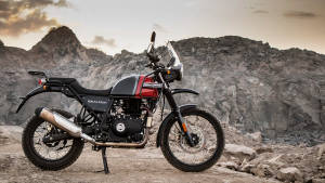 Royal Enfield Himalayan 摩托車在黃昏時停泊在岩石地形上。 — 腳踏車 GIF 壁紙