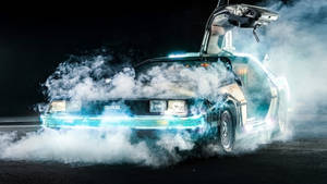 DeLorean時光機在夜晚的煙霧中飄移，發出藍色光芒。 — 藍色煙霧 壁紙
