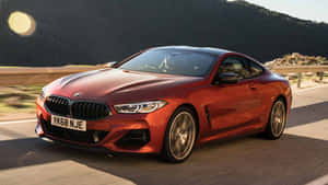 紅色BMW 8系列雙門轎跑車在日落時分於山路上疾馳。 — Mercedes-Benz 壁紙