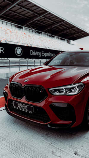 紅色BMW X6 M Competition在賽車場上，有看台。 — 可愛的機器人 壁紙