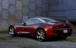 紅色Fisker Karma跑車停放在混凝土牆旁碎石上。 — MacBook Air M1 壁紙