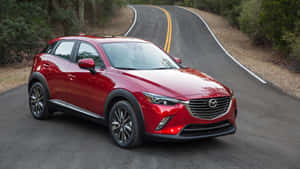 白天在蜿蜒森林道路上的紅色Mazda CX-3 SUV。 — 馬自達 壁紙