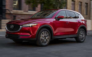 紅色Mazda CX-5 SUV在都市街道上行駛，帶有動態模糊效果。 — 馬自達 壁紙