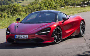 紅色McLaren 720S跑車在鄉村道路上，背景有綠色山丘。 — 麥拉倫 720S 壁紙