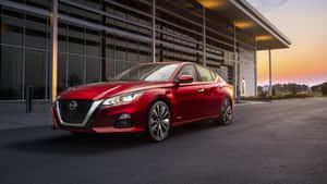 紅色日產Altima停放在現代建築外，日落時分。 — 日產 壁紙