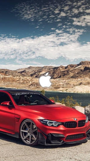 紅色BMW M4停在沙漠湖邊，山上帶有Apple標誌 — 汽車 iPhone 壁紙