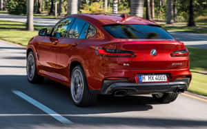 紅色BMW X4 M40i SUV在陽光明媚的林蔭大道上行駛 — Steam Deck OLED 壁紙