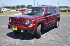 紅色Jeep Patriot SUV停放在陽光明媚的戶外停車場。 — 吉普 壁紙