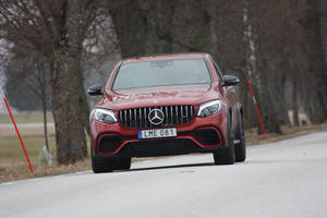 紅色Mercedes-AMG GLE63 S SUV在鋪設的道路上行駛，兩旁是光禿禿的樹木。 — Mercedes Benz C300 壁紙
