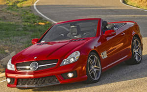 紅色Mercedes-Benz SLR McLaren敞篷車停泊在日落時分的彎曲道路上。 — Mercedes-Benz 壁紙