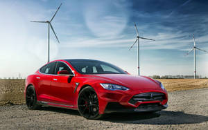 日落時分，紅色Tesla Model S Performance停泊在風力發電機附近。 — 特斯拉 壁紙