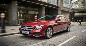 紅色梅賽德斯-奔馳轎車在城市中行駛，帶有動態模糊效果。 — Mercedes Benz C300 壁紙