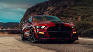 黃昏時分，紅色福特野馬Shelby GT500行駛在山路上。 — 福特 壁紙