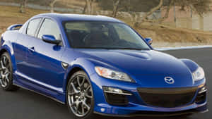 藍色Mazda RX-8跑車在日落時分的賽道上。 — 馬自達 壁紙