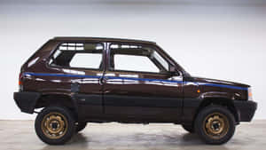 攝影棚中的棕色Fiat Panda 4x4，配金色輪圈和藍色條紋。 — 可愛熊貓 壁紙