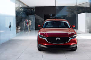紅色Mazda SUV在簡約玻璃牆展廳中，地板反射。 — 馬自達 壁紙