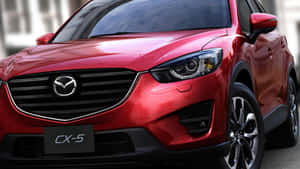紅色Mazda CX-5 SUV正面視圖，帶有鍍鉻格柵和合金輪圈。 — 馬自達 壁紙