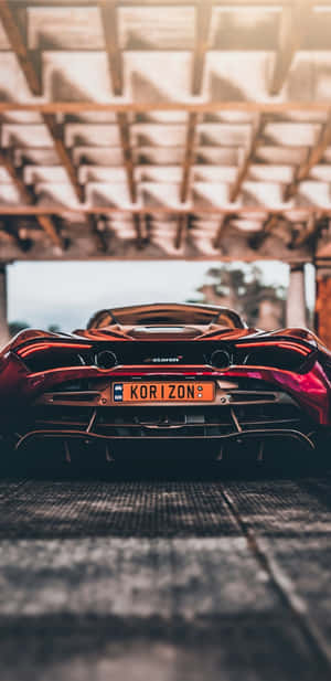 紅色McLaren跑車在日落時停放在木製車庫屋頂下。 — 跑車 壁紙