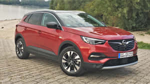 紅色Opel Grandland X SUV停泊在河邊鵝卵石上 — 歐寶 壁紙