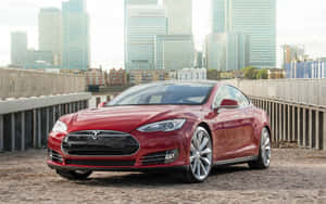 紅色Tesla Model S在石橋上，背景有玻璃摩天大樓。 — 特斯拉 壁紙