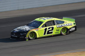 一輛萊姆綠和黑色的NASCAR賽車在賽道上飛馳。 — 好看汽車 壁紙