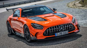 橙色 Mercedes-AMG GT R 跑車停在鵝卵石路上。 — 赤犬 壁紙