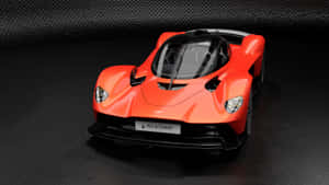 橙色Aston Martin Valkyrie hypercar在深色紋理表面上。 — 奧斯頓馬丁 壁紙