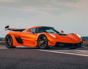 橙色Koenigsegg hypercar在瀝青賽道上於日落時分 — 超跑 壁紙