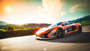 橙色McLaren 650S賽車在日落時分的山路上奔馳。 — iMac 壁紙