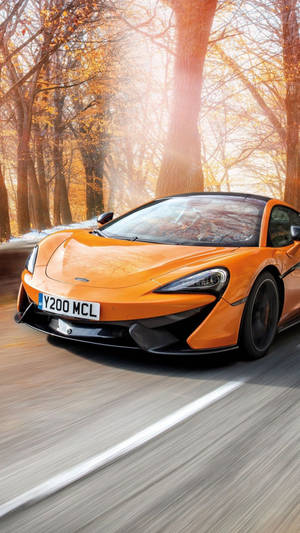 橙色McLaren在秋日森林中於夕陽下疾馳 — 日落 壁紙