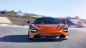 橙色McLaren賽車在賽道上疾馳，帶有動態模糊效果 — 麥拉倫 720S 壁紙