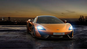 橙色McLaren 570S跑車在暮色中停在濕漉漉的路面上，背後是城市燈光。 — 麥拉倫 壁紙