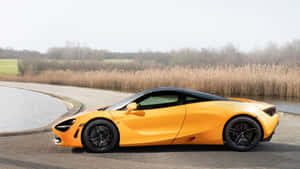 橙色McLaren 720S跑車停放在水道旁，有蘆葦。