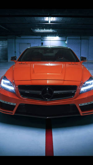 橙色梅賽德斯跑車停在光線昏暗的地下車庫，帶有紅色條紋。 — Mercedes Amg iPhone 壁紙