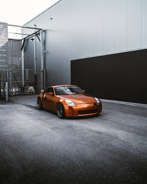橙色跑車停在工業建築前 — 日產 壁紙