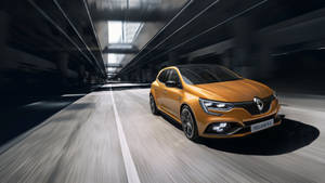 橙色雷諾 Mégane R.S. 在黑暗隧道中疾馳，帶有動態模糊。 — 雷諾 壁紙