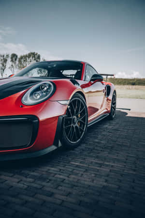 白天鵝卵石路上的紅色保時捷911 GT2 RS。 — 榮耀MagicPad 3 壁紙